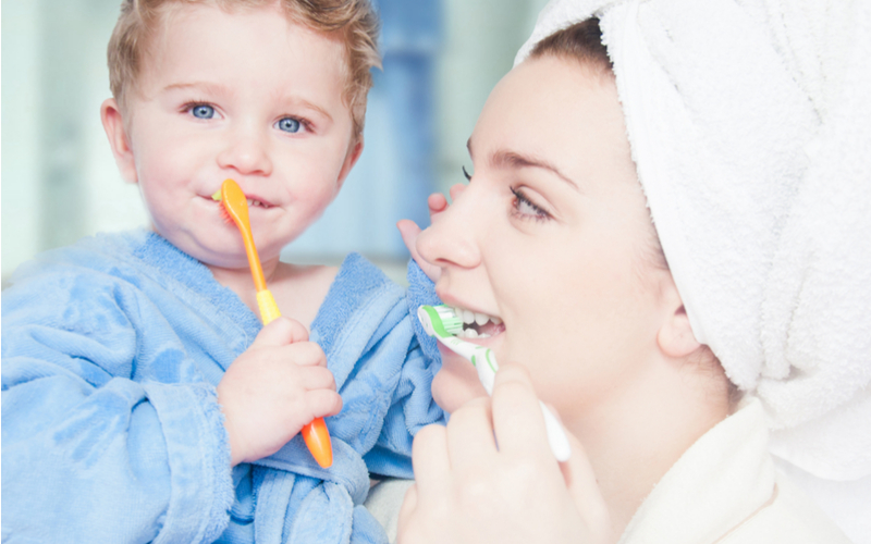 mom teaching child how to brush teeth